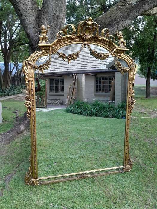 A French Style Ornately Carved And Gilded Bevelled Mirror Of Large Proportions
