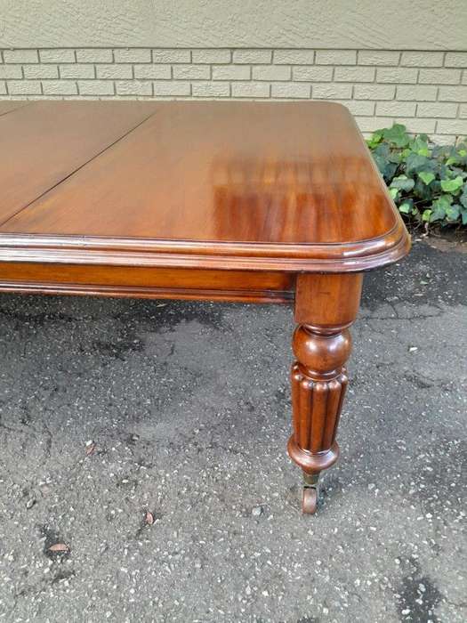 An Antique Edwardian Extending Dining Table with Heavily Carved Legs on Castors and with Crank Ha...