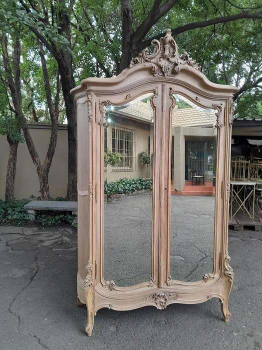 An Antique French Heavily Carved Oakd Two Door Armoire with Bevelled Mirrors and Four Shelves