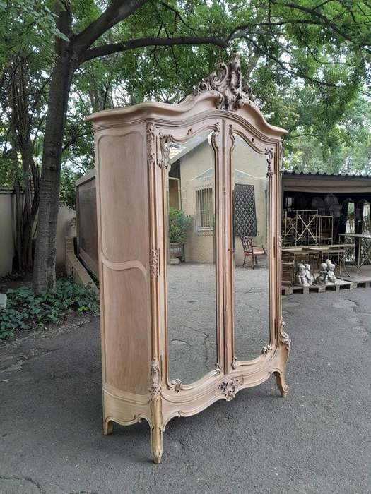 An Antique French Heavily Carved Oakd Two Door Armoire with Bevelled Mirrors and Four Shelves