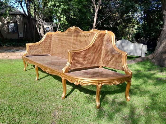 A 20th Century French Style Carved and Gilded Conversation Settee in Rattan