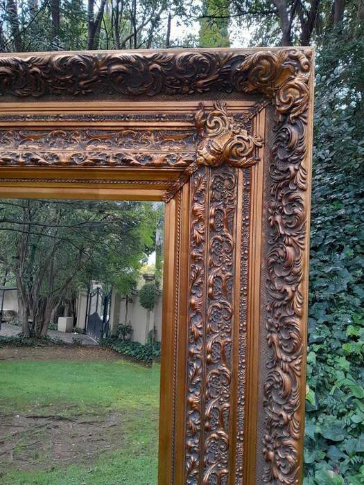 A 20th Century Heavily Carved And Bevelled Framed Mirror Of Large Proportions