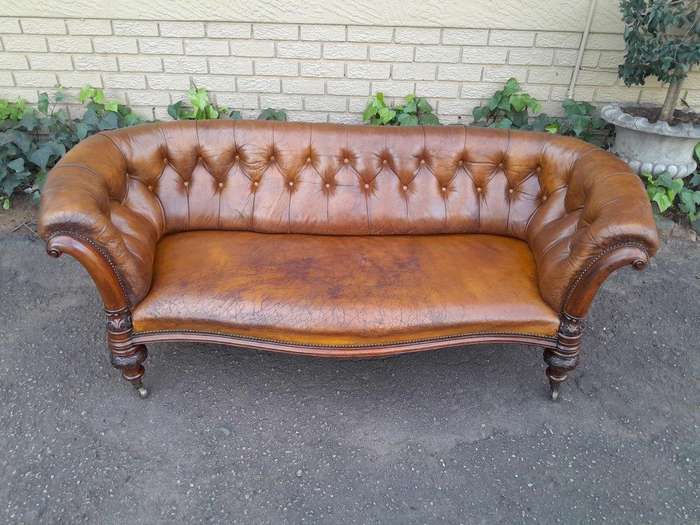 An Antique 19th Century Chesterfield Settee With Original Leather And Castors