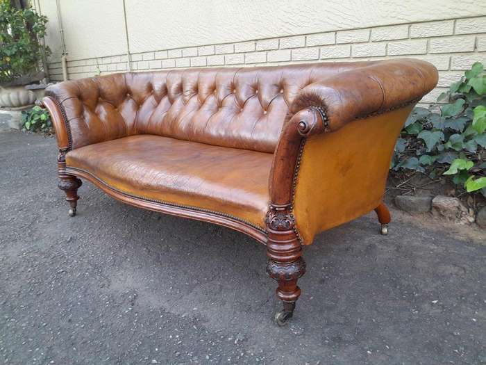 An Antique 19th Century Chesterfield Settee With Original Leather And Castors