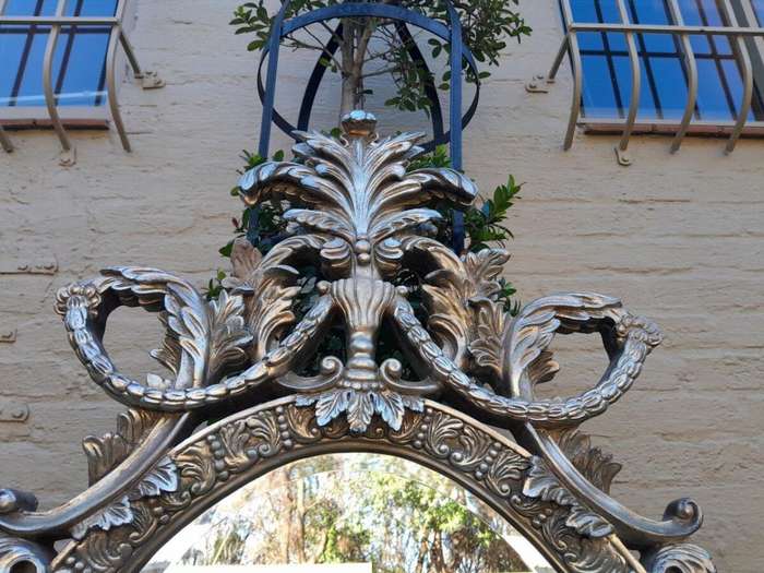A French Style Ornately Carved And Bevelled Mirror In A Contemporary Silver Hand-Gilded Finish