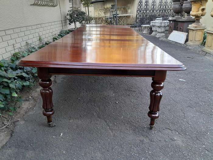 An Antique  Circa 1880s Victorian Mahogany Extending Dining Table On Castors With Four Leaves A...