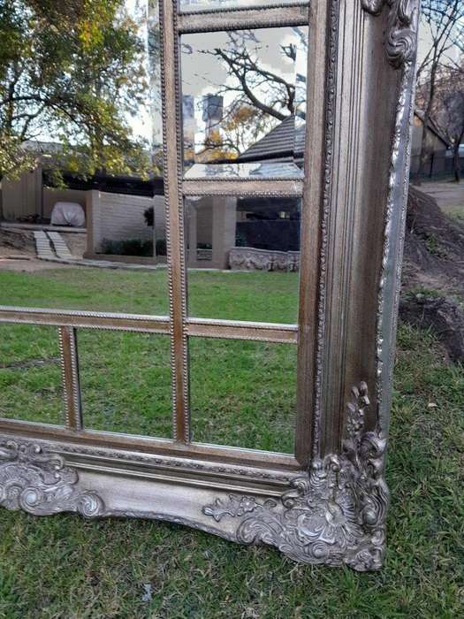 A 20th Century French Style Ornately Carved, Gilt Painted And Bevelled Mirror