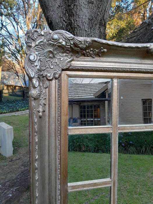 A 20th Century French Style Ornately Carved, Gilt Painted And Bevelled Mirror