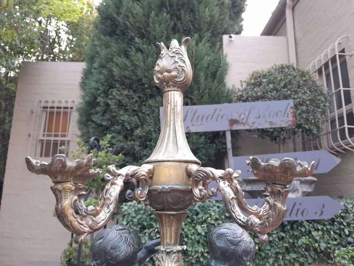 An Antique Brass And Bronze Five Arm Cherub Candelabra
