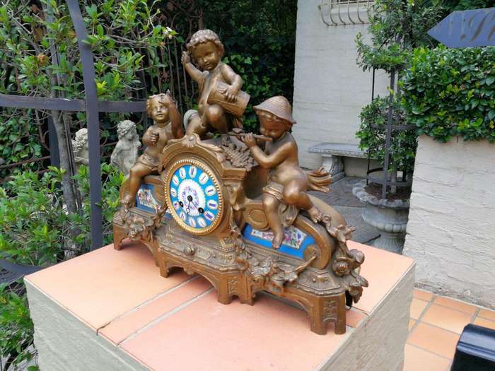 A 20th Century French Spelter And Gilt And Spelter Clock With Porcelain Plaques. Has Key And Pen...