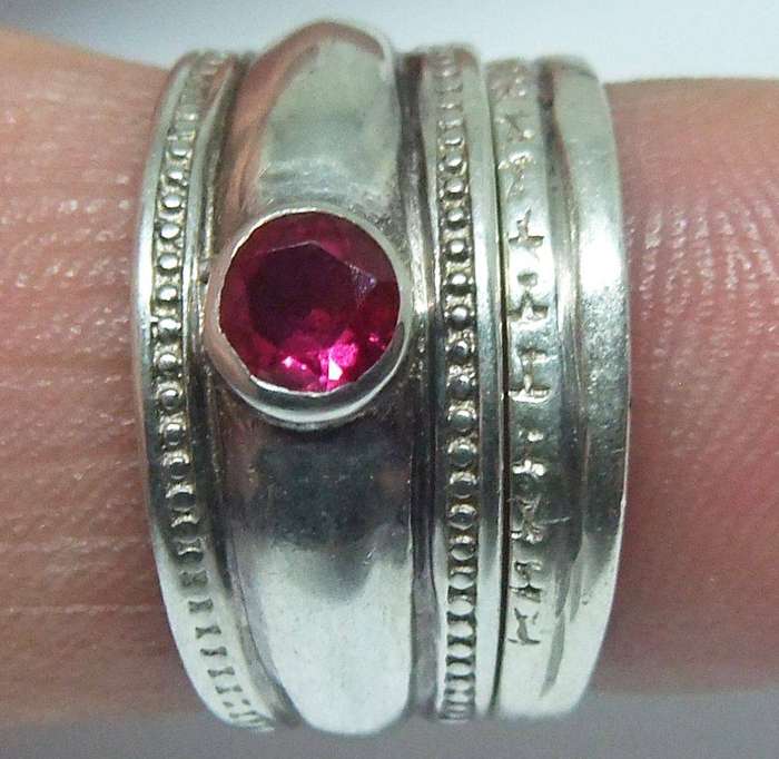 A beautiful two piece sterling silver ring with ruby coloured faceted inset