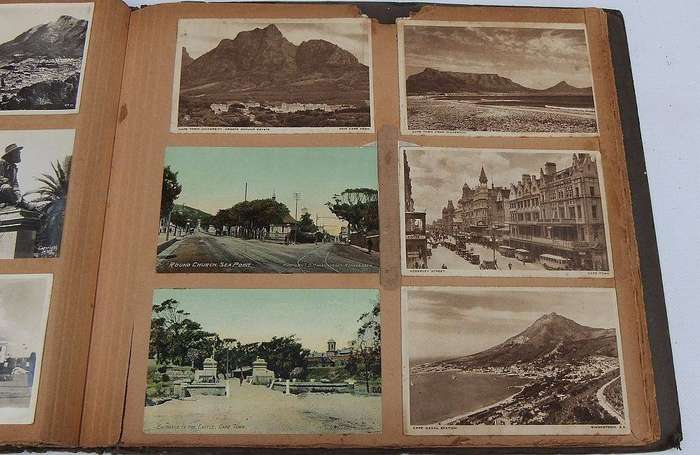 A large old album filled with over 200 vintage and antique postcards