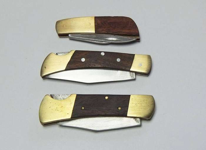 A lot of three vintage brass and wood folding pocket knives