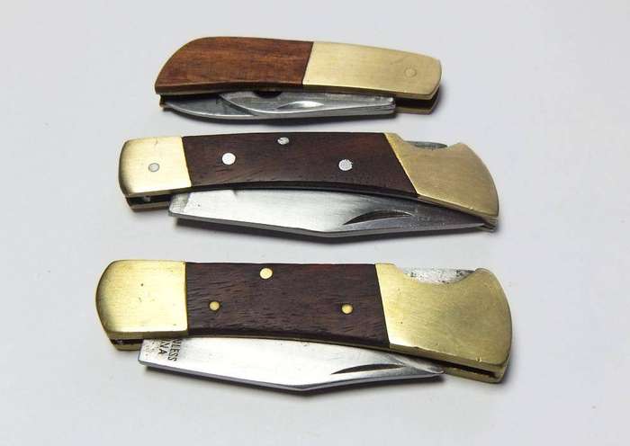 A lot of three vintage brass and wood folding pocket knives