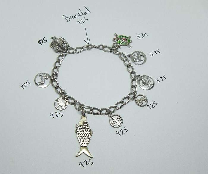 A VERY COOL VINTAGE STERLING SILVER CHARM BRACELET WITH VARIOUS DEGREES OF SILVER CHARMS , JUST LOOK