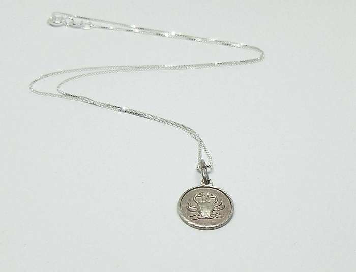 A vintage sterling silver Cancer Zodiac sign pendant with a sterling silver necklace