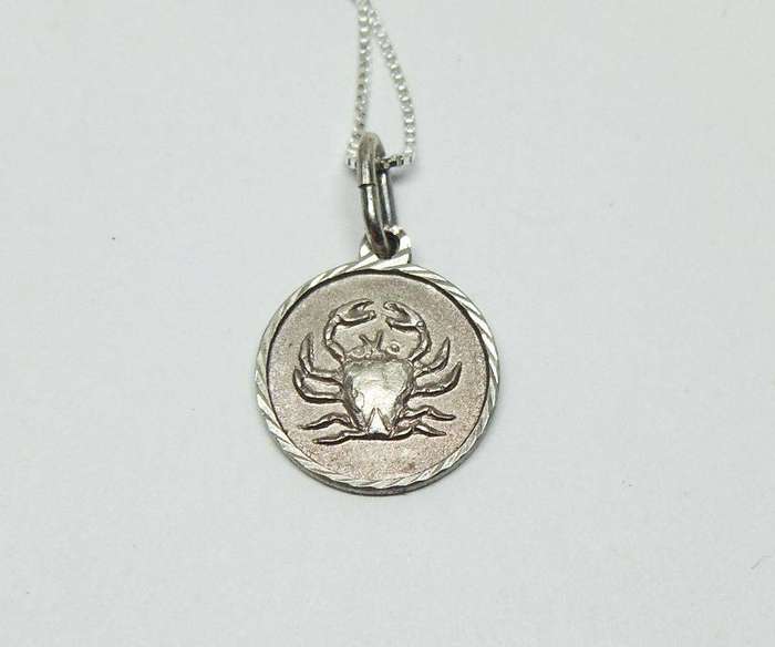 A vintage sterling silver Cancer Zodiac sign pendant with a sterling silver necklace
