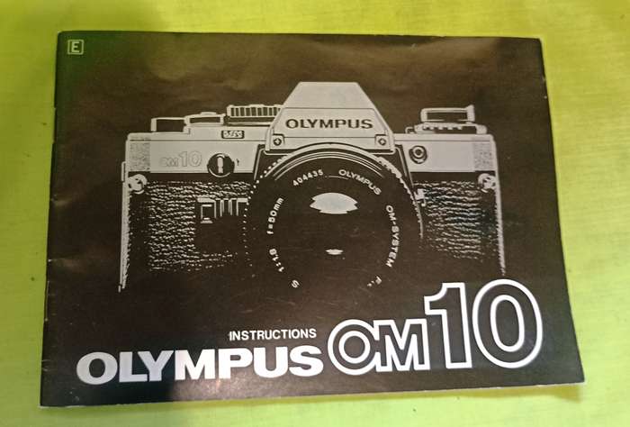 Olympus OM-10 camera with 50mm F 1.8 lens/light filters/lens cap/body cap/leather cover/manual