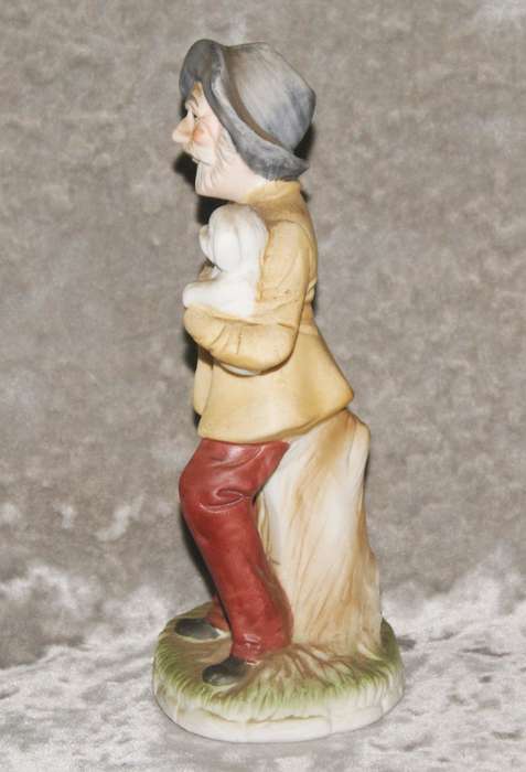 Vintage ceramic figurine of man holding dog
