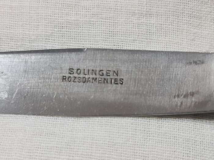 Three knifes with ornate handles and monogram on handle.