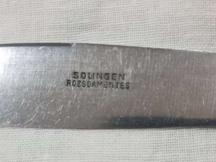 Three knifes with ornate handles and monogram on handle.