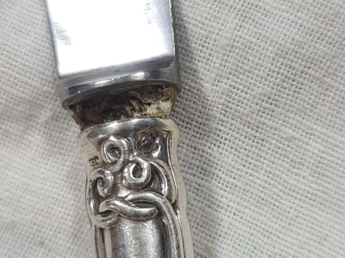 Three knifes with ornate handles and monogram on handle.