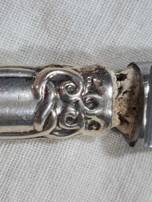 Three knifes with ornate handles and monogram on handle.