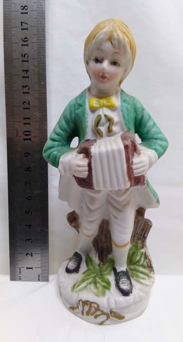 Boy playing accordian porcelain figurine