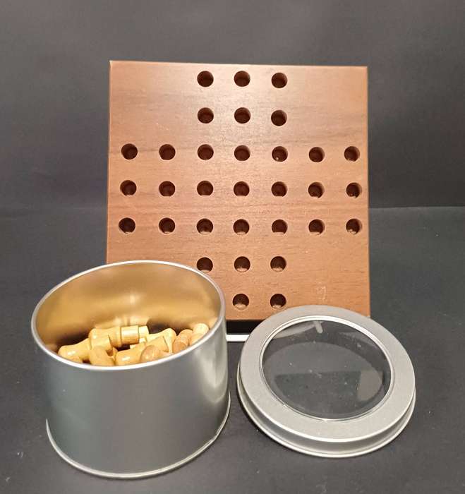Solid dark wood solitaire board with light wood pegs