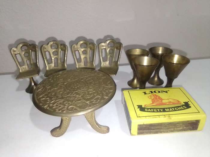 Handcrafted miniature bras dining table set that includes a table and four chairs and 4 goblets.