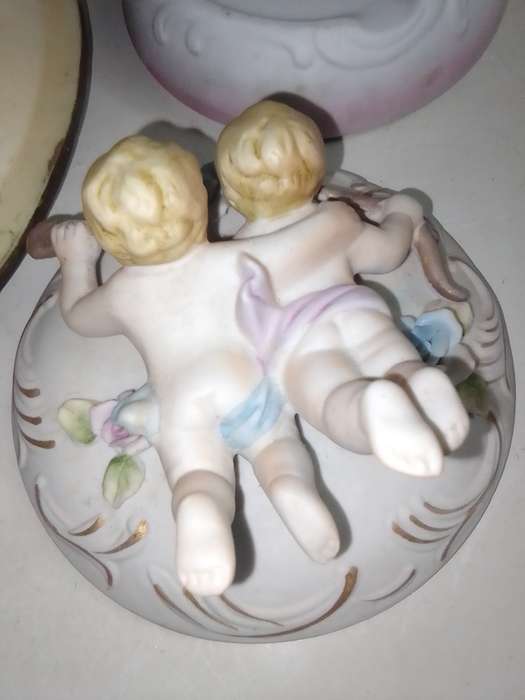 A Damsel and cherub Porcelain/polyresin wall plaque and a Cherub trinket lidded box.