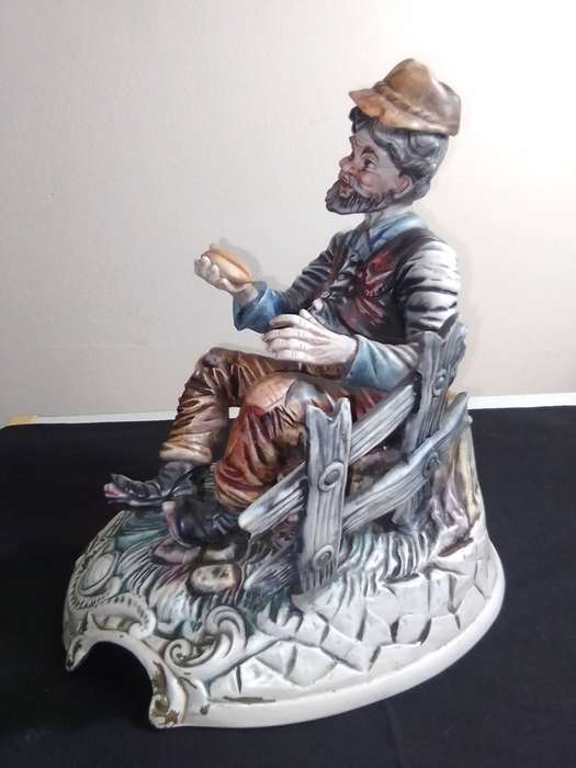Very Large and impressive. Capodimonte Porcelain Hobo/Tramp/Begger man on Bench with bun in hand.
