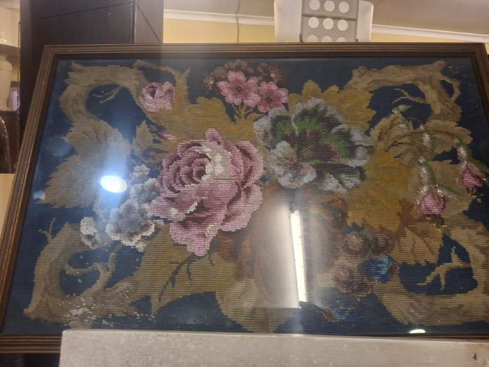 Stunning beaded rose taperstry behind glass