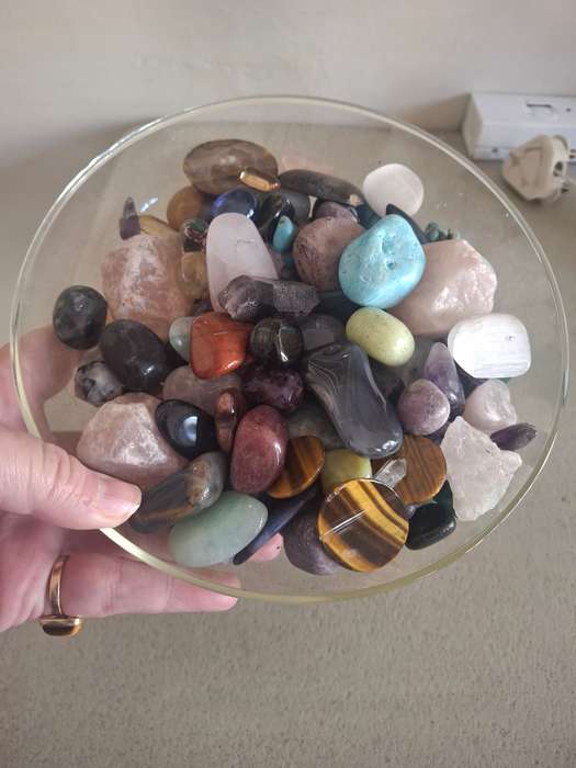 A glass bowl full of semi precious stones crystals