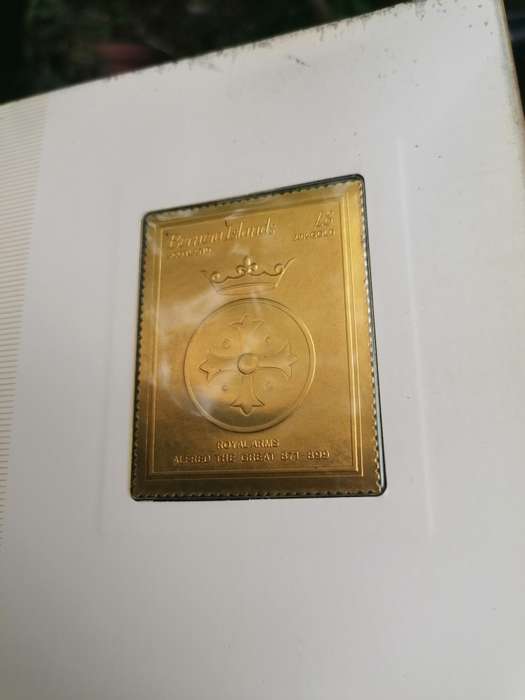 A BOOK of 22k Gold postage stamps, "The Royal Coats of Arms of the Kings and Queens of England", ple