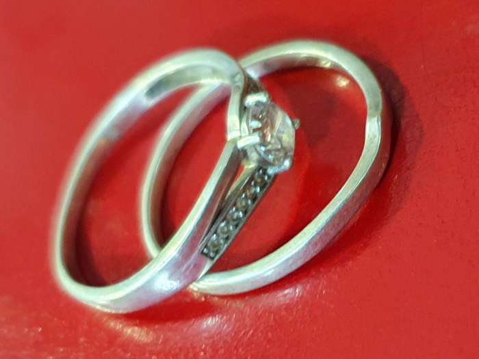 STERLING SILVER ENGAGEMENT RING WITH POLISHED STONE AND WEDDING BAND.