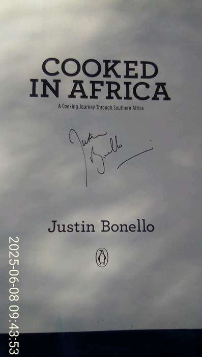 SIGNED.  "Cooked in Africa" Justin Bonello.  Soft cover.