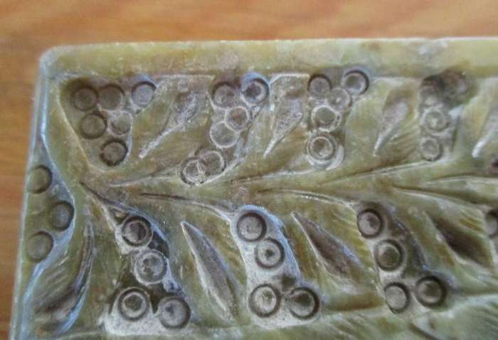 A vintage ornately carved stone trinket box with hinged lid