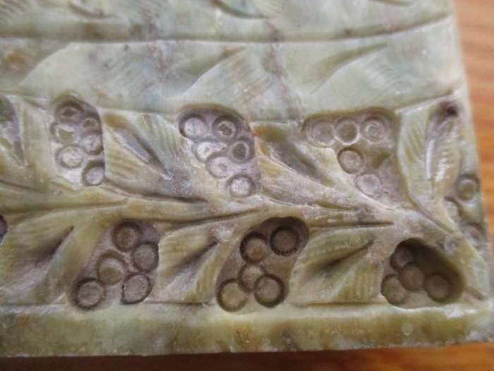 A vintage ornately carved stone trinket box with hinged lid
