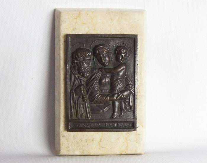 An old bronze plaque deskpiece depicting The Holy Family on an either marble or alabaster base