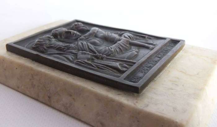 An old bronze plaque deskpiece depicting The Holy Family on an either marble or alabaster base