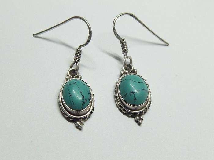 A pair of vintage sterling silver earrings set with cabochon Turquoise stones