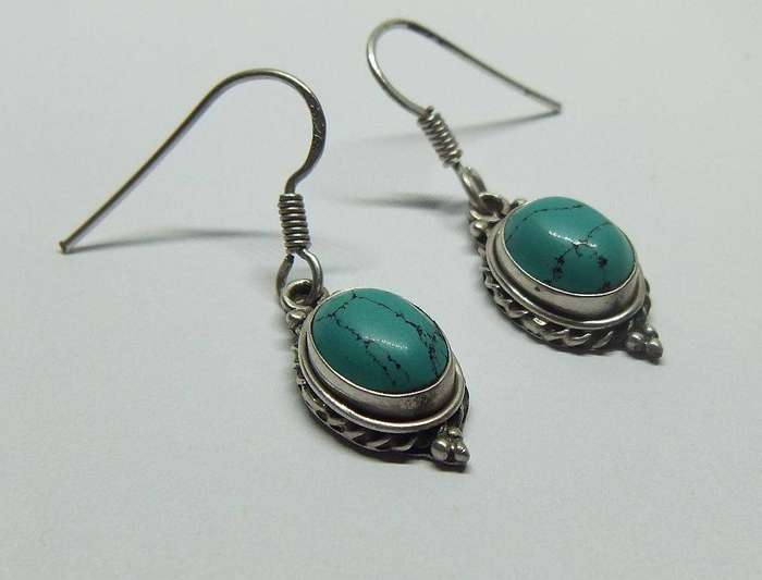 A pair of vintage sterling silver earrings set with cabochon Turquoise stones
