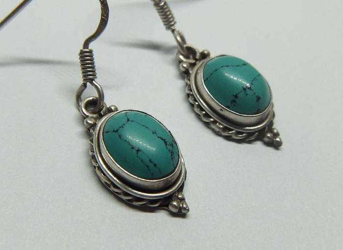 A pair of vintage sterling silver earrings set with cabochon Turquoise stones