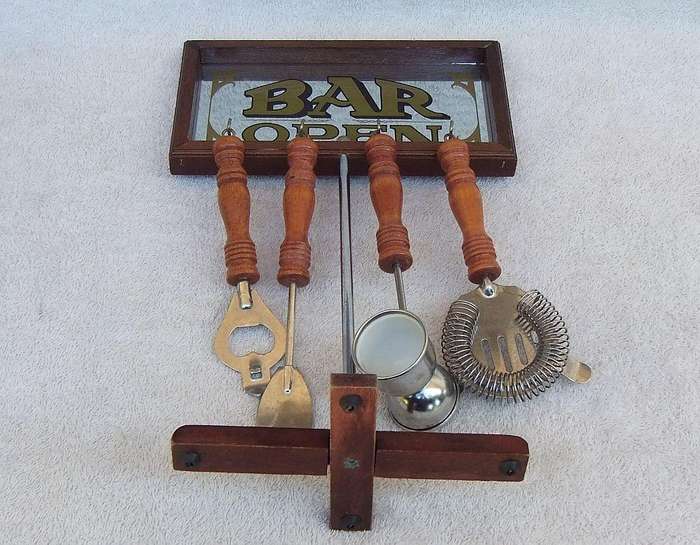 A vintage bar tool stand with mirror and accessories