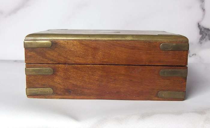 A vintage hand made wooden trinket or jewelry box with brass fittings and inlay