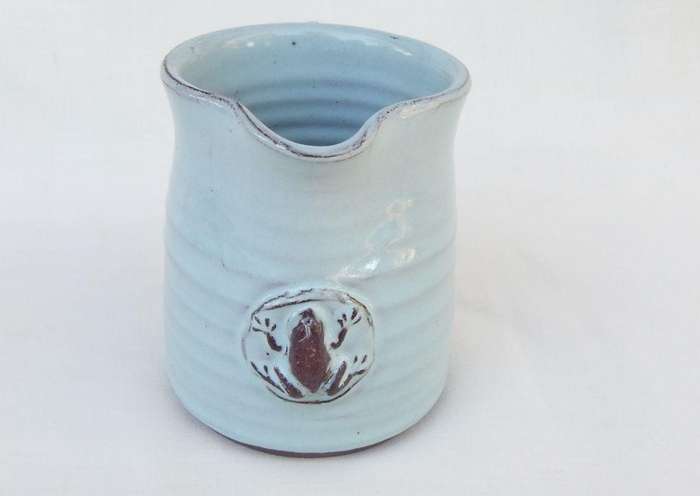 A signed South African pottery mug with frog motif