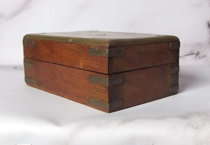 A vintage hand made wooden trinket or jewelry box with brass fittings and inlay
