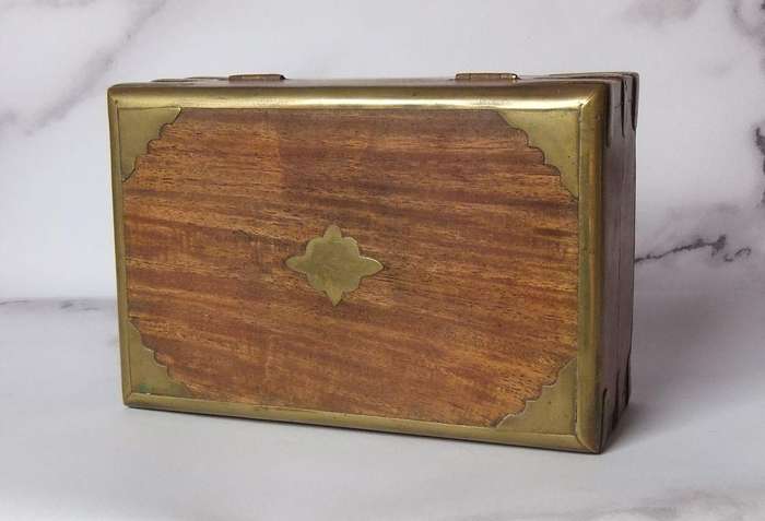 A vintage hand made wooden trinket or jewelry box with brass fittings and inlay
