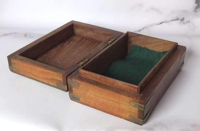 A vintage hand made wooden trinket or jewelry box with brass fittings and inlay